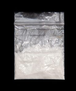 Eutylone powder in a small glass container, representing a synthetic cathinone research chemical commonly used in various applications.