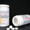 An image of oxycodone tablets or capsules, typically used for pain management, highlighting their prescription-only status and potential risks of misuse.